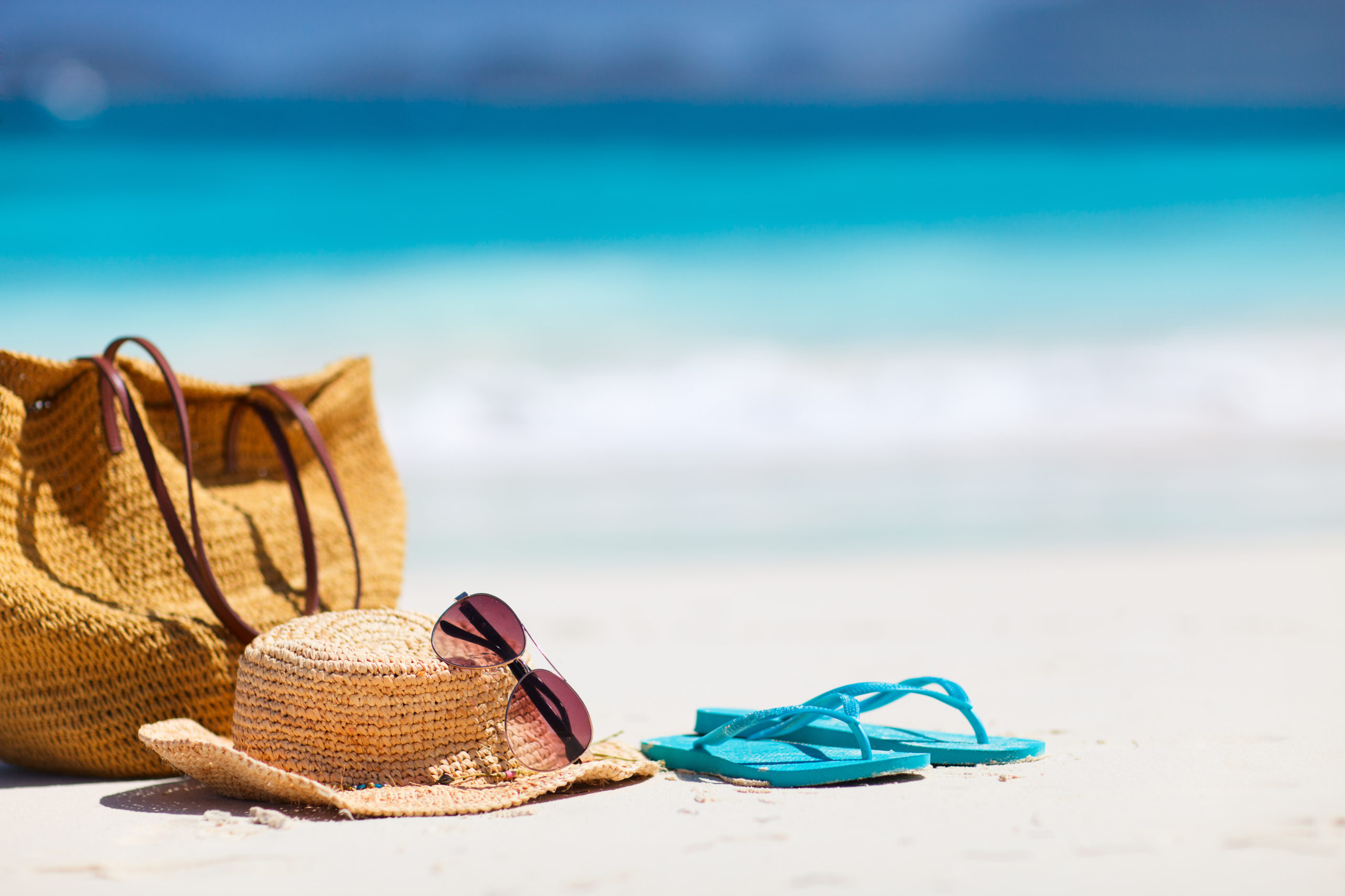 Hat and flipflops on a beach