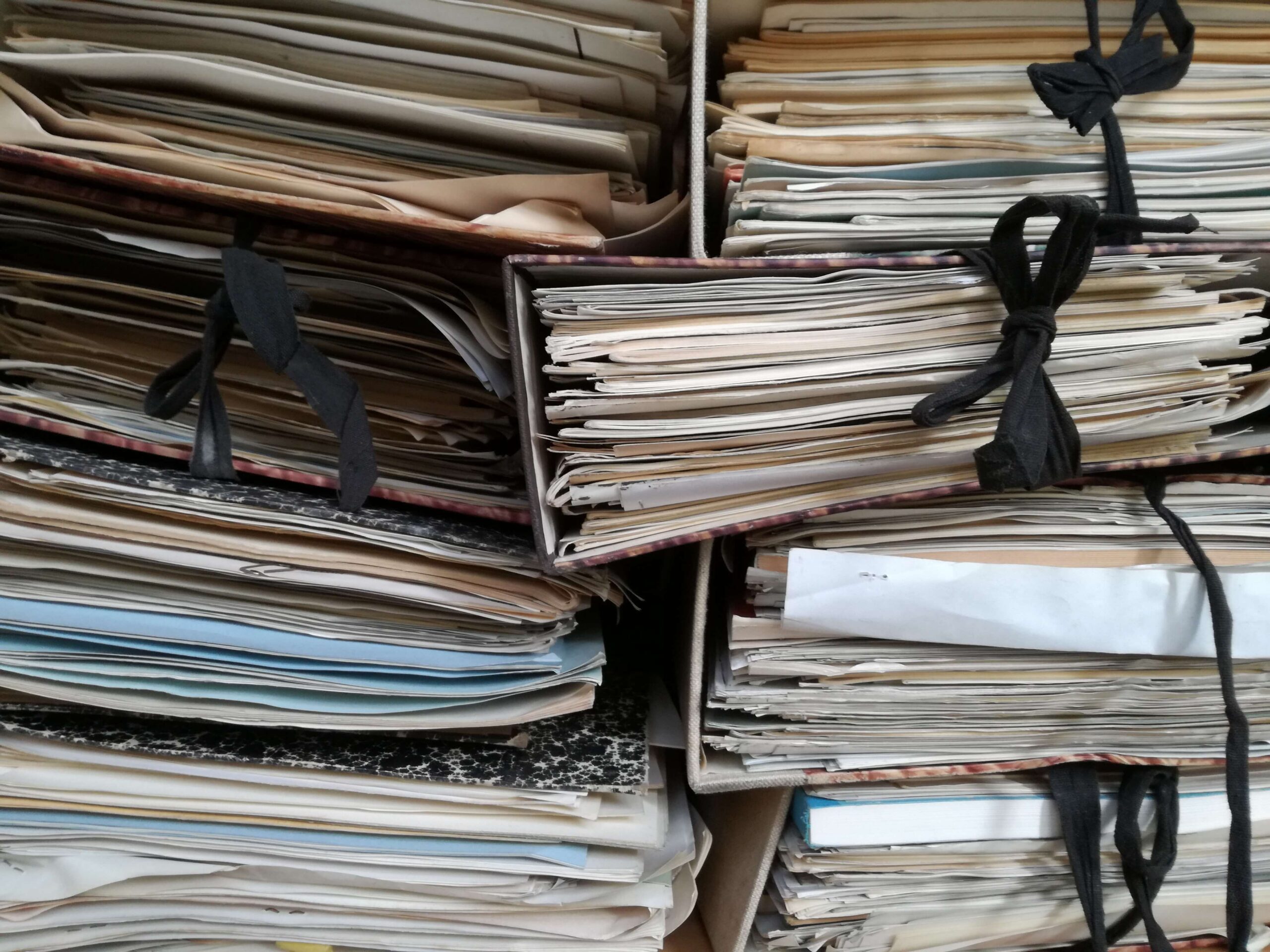 A close up of a stack of folders stuffed full of sheets of paper